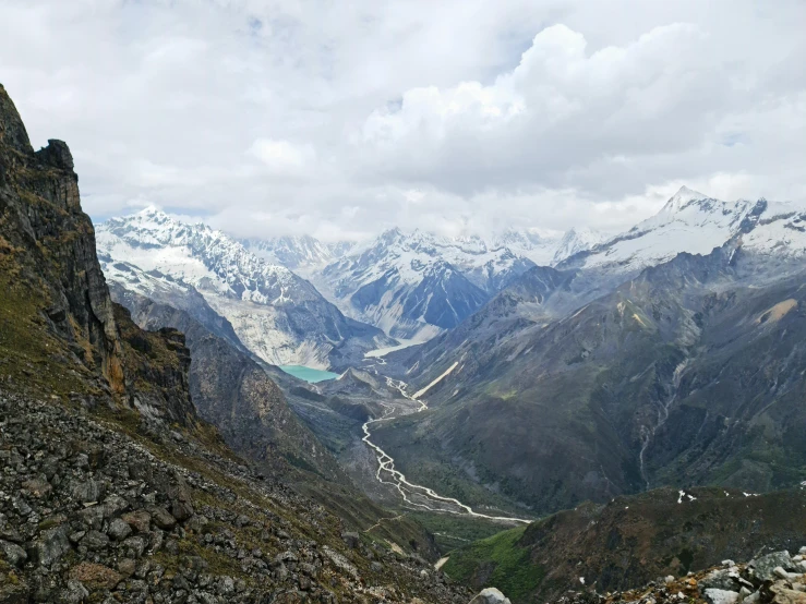 mountain range with trees and other rocks under clouds