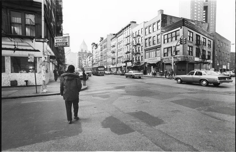 a black and white po of an older man walking across a street