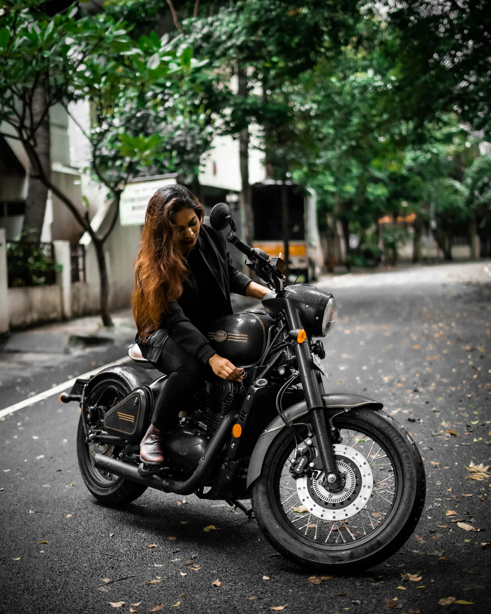 a woman is sitting on a motorcycle on the street