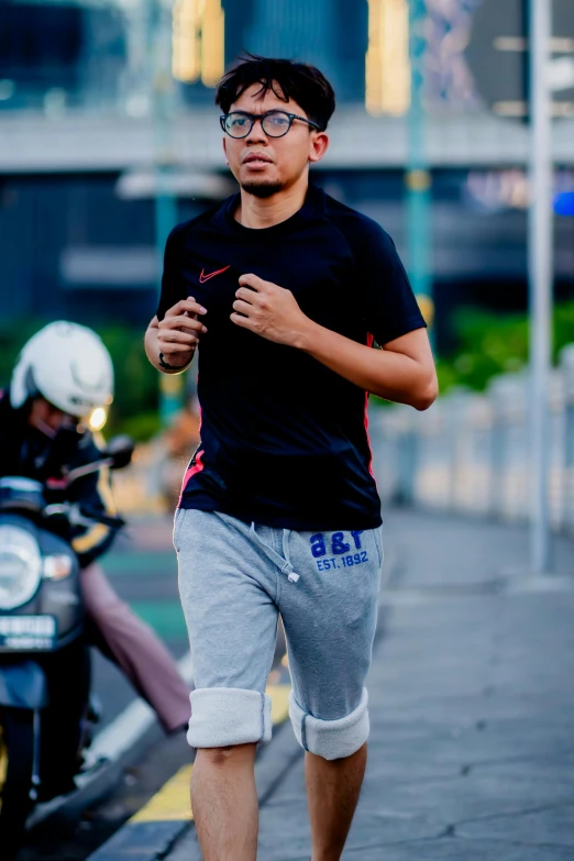 man in black shirt and glasses running down street