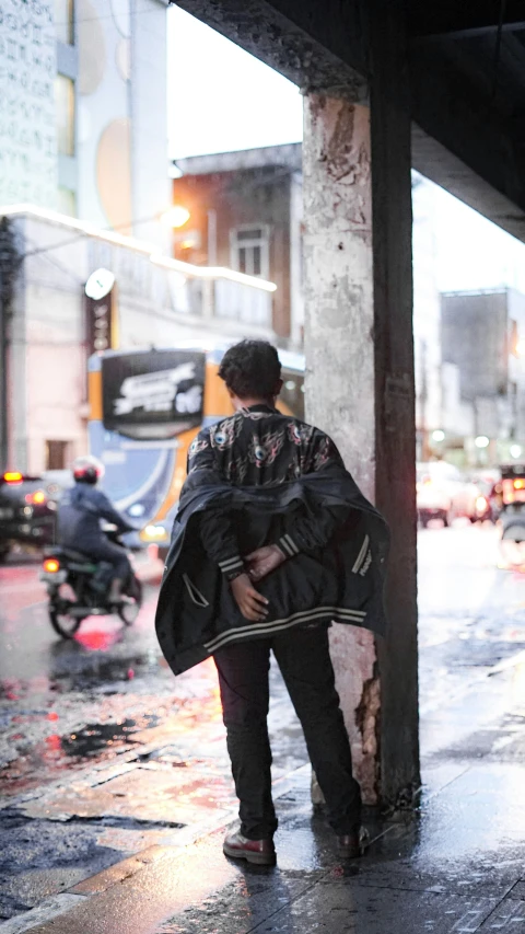 a young man walks under the shelter of an umbrella