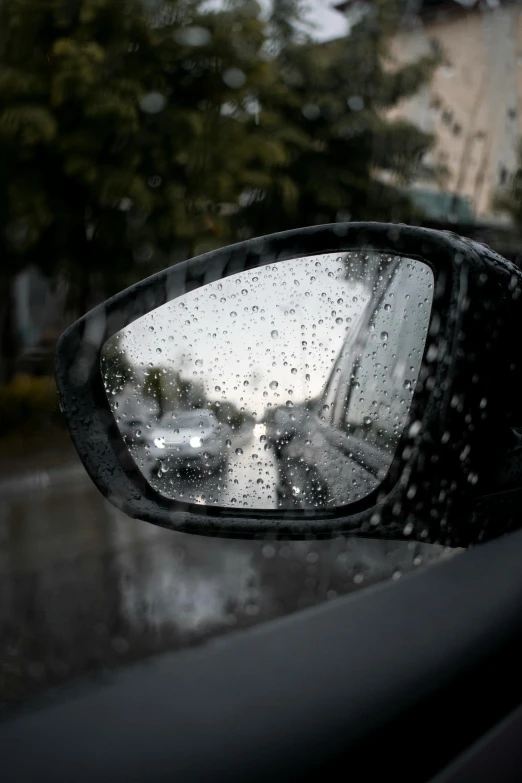 the rear view mirror is covered in rain