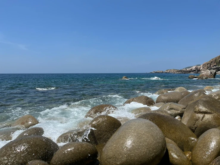 waves crash over the rocks near a beach