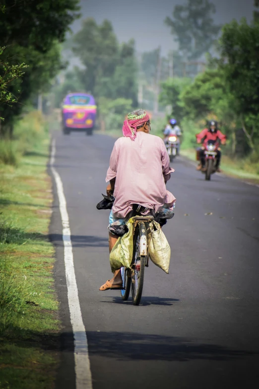 several people on motorcycles riding down a street