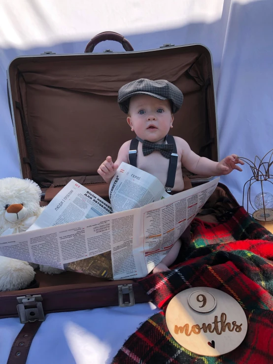 a baby is sitting in an old suitcase