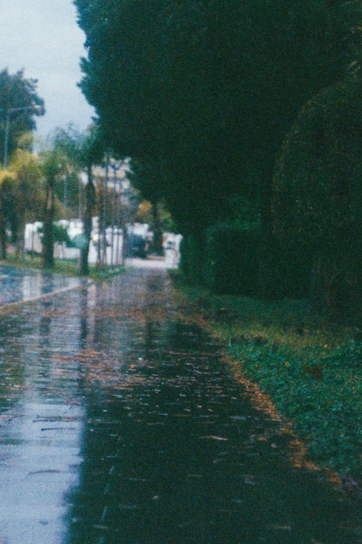 rain is pouring down on the street and some cars