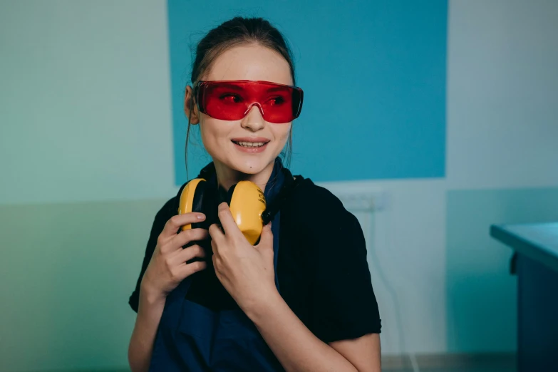 a woman wearing red goggles and holding a banana