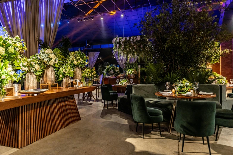 a restaurant with large green plants and furniture