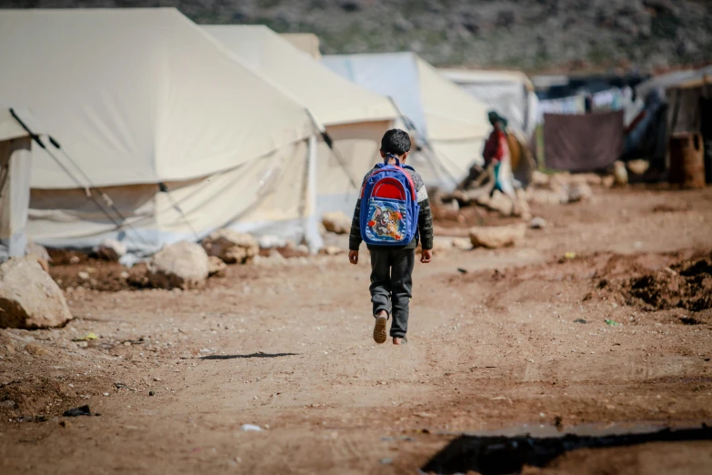 a young child walking down a dirt road