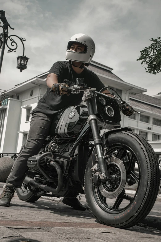 the motorcyclist in a helmet is riding his bike in front of a large white building