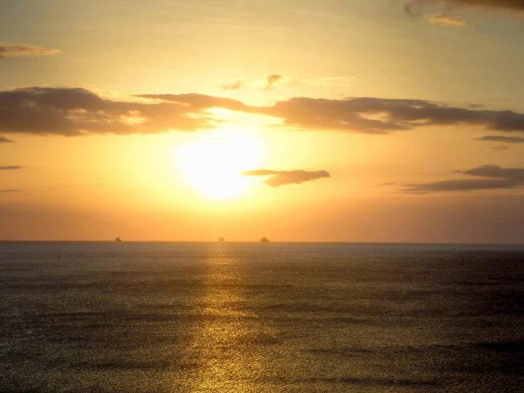 two boats in the distance near the sun setting