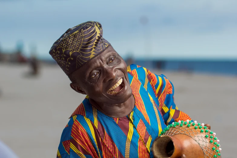 a colorfully dressed man is holding his wooden instrument