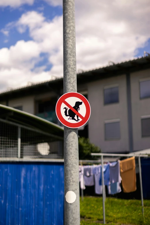 a red sign on top of a pole near a building