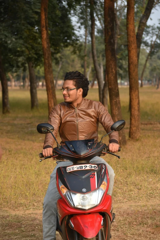 a man with glasses on sitting on top of a motorcycle