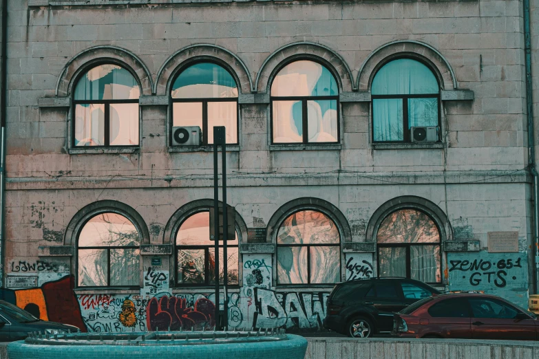 a rundown building with several windows and graffiti