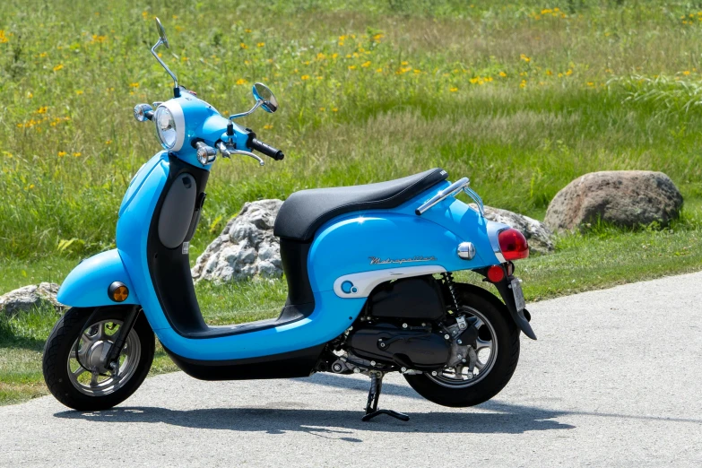 a blue scooter parked on the side of the road