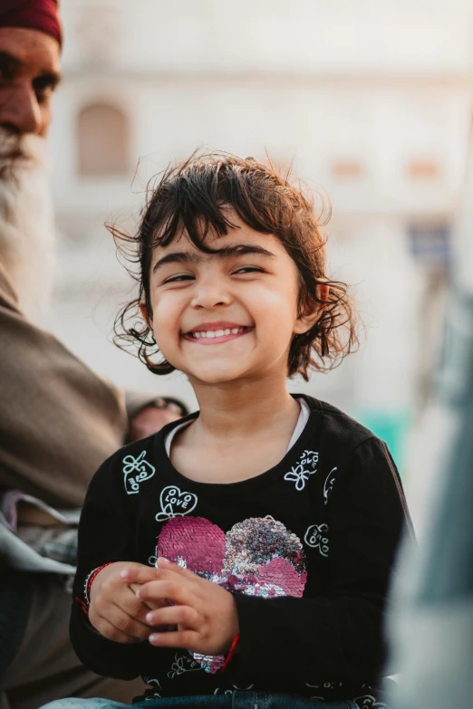 a child sitting on the ground laughing at someone