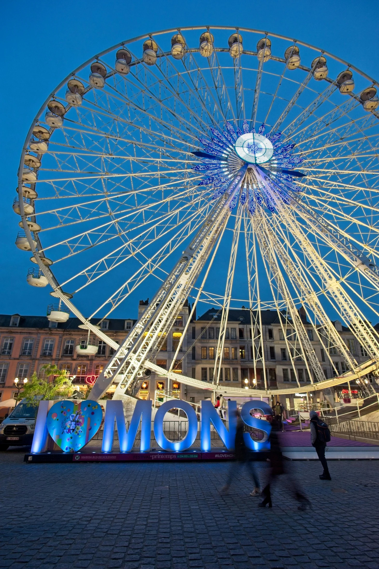 a ferris wheel at night with the word mom lit up