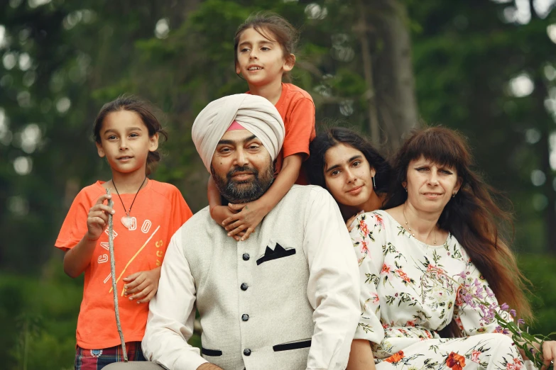 a family poses for a portrait outdoors in the park