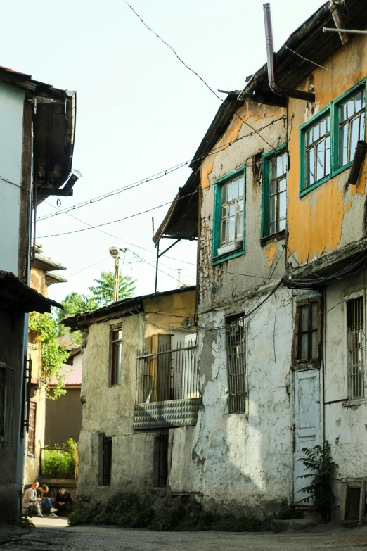 a dilapidated building with windows on two sides and balconies