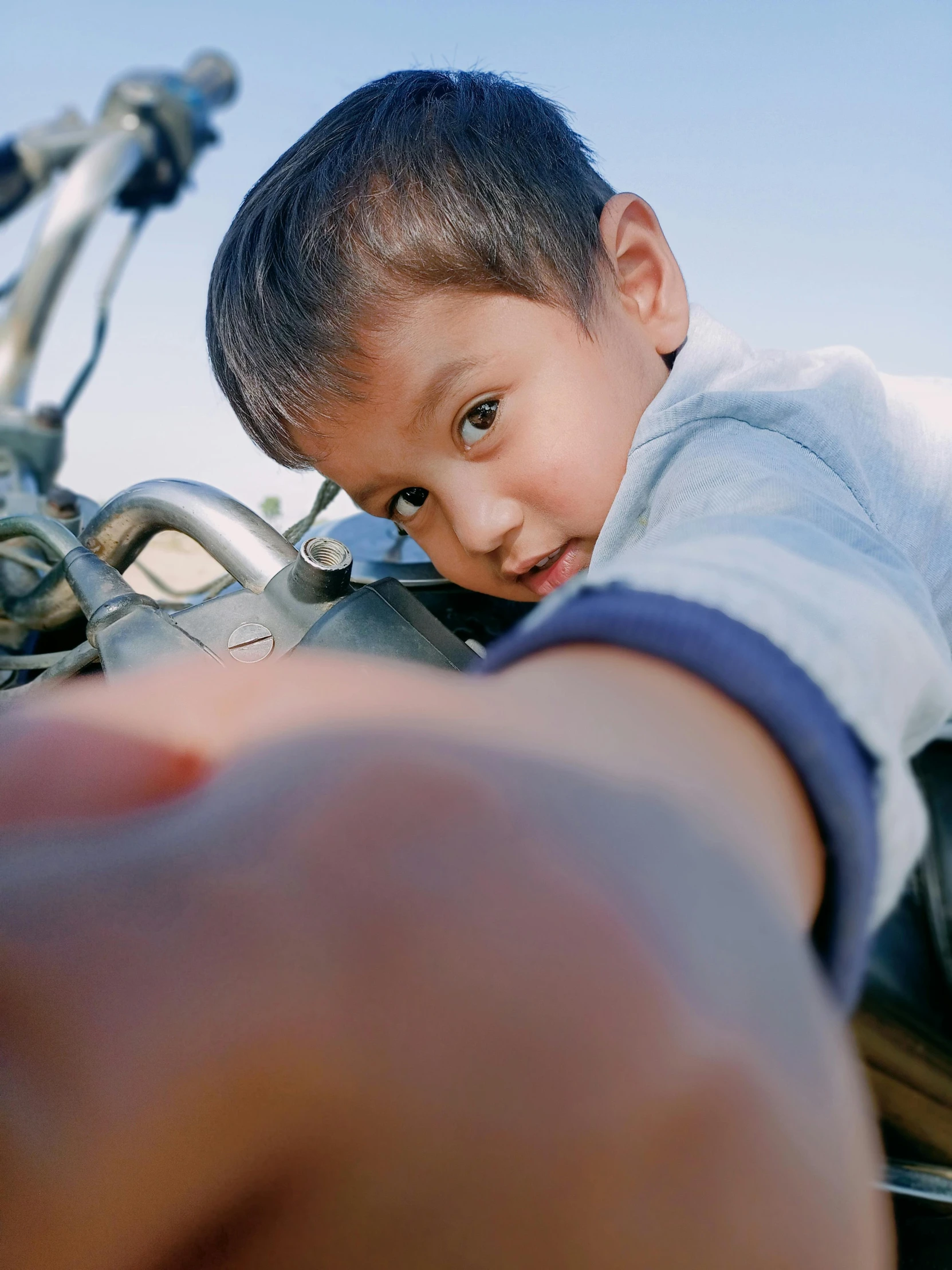 a little boy has a hand out near a bike