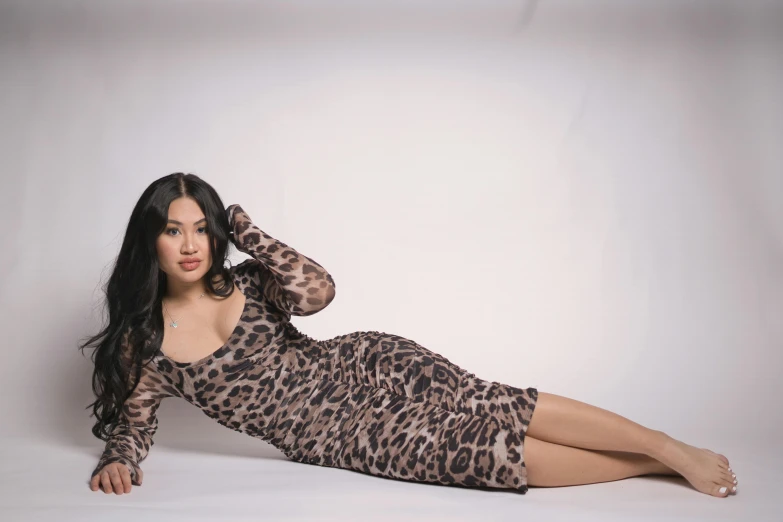 a beautiful young lady posing in a brown leopard print dress