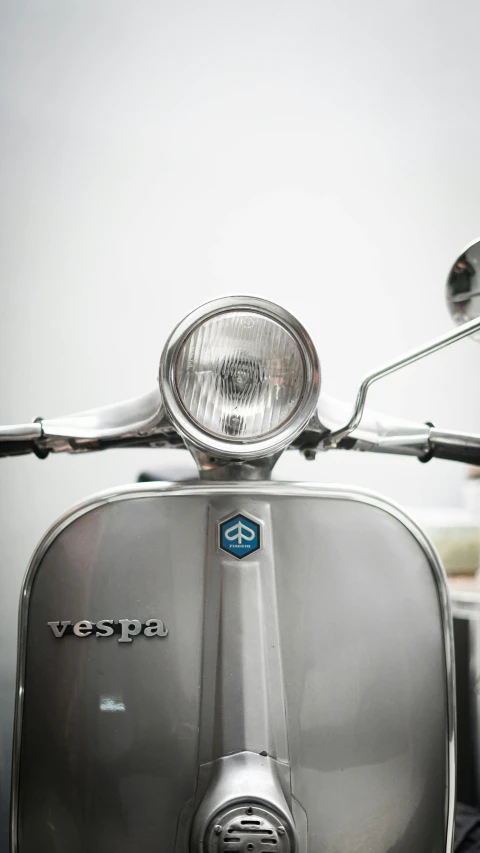 a very nice looking silver vespa motorcycle parked