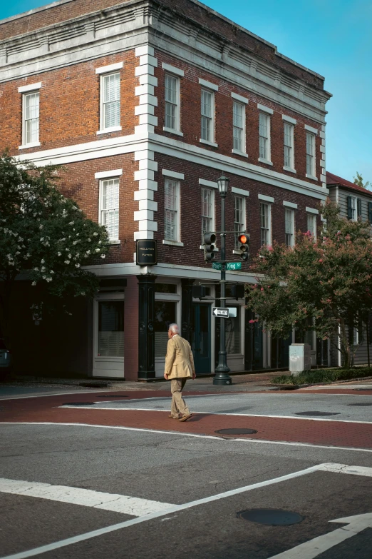 man crossing an intersection in front of building in a city