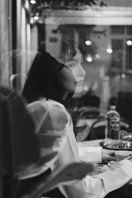 black and white pograph of woman in restaurant eating