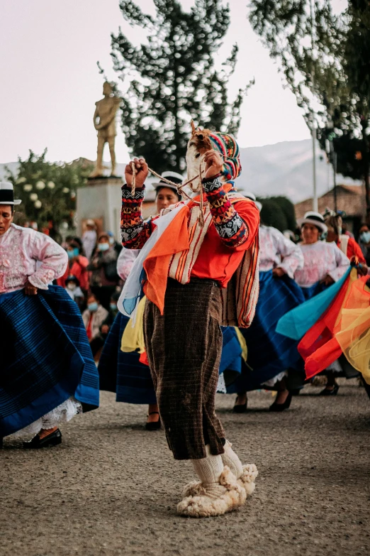 performers are in various costumes during a parade