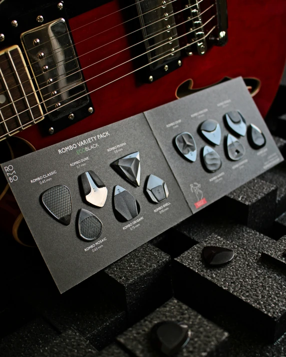 several musical instrument picks on display, one with an electric guitar in the background