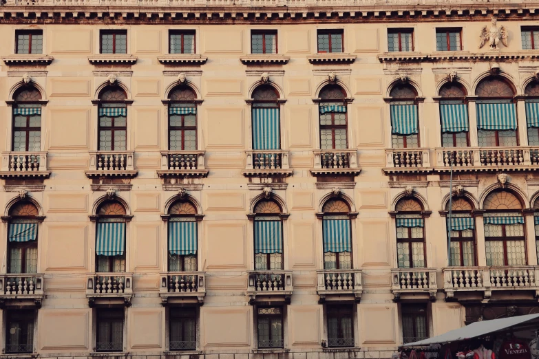 an antique building with balconies, a balcony and a canopy on the top floor