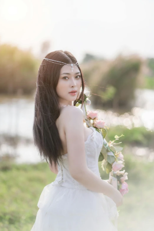 a woman in wedding dress posing for a po with flowers in her hair