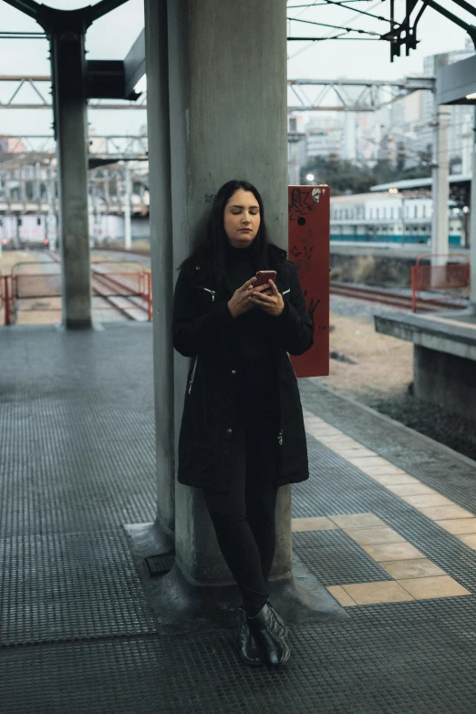 a woman standing on a platform next to a pillar