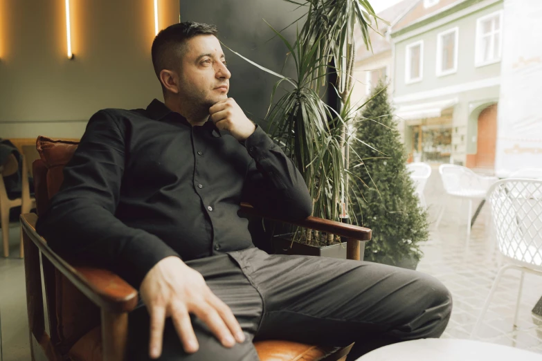 a man sitting on a chair outside looking ahead