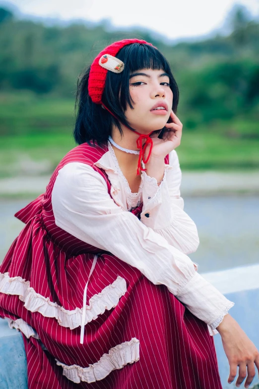 an asian woman in a red dress is holding a cell phone