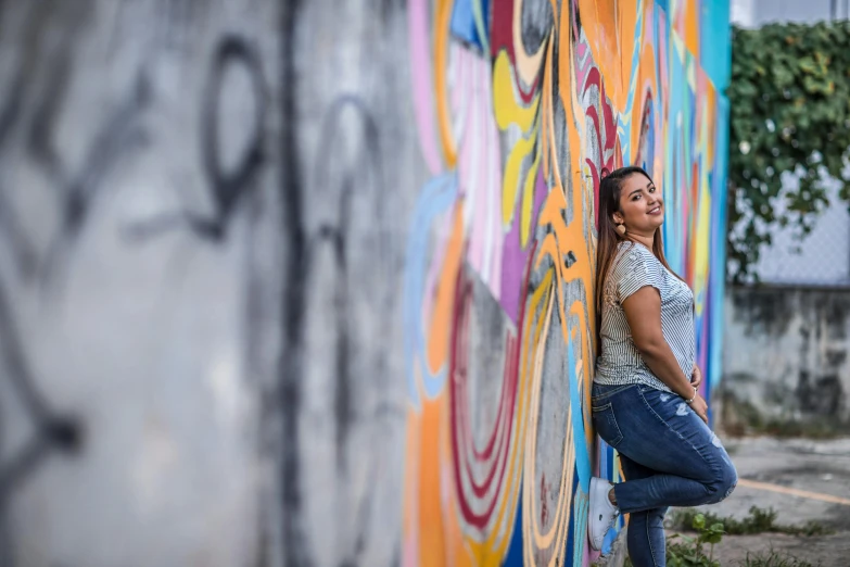 a woman standing in front of some graffiti