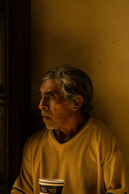 a man with gray hair holding a cup