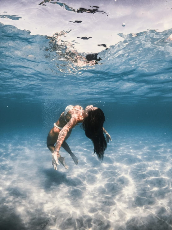 a woman swimming on the water with her legs up