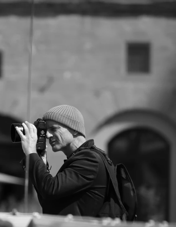 a man with a hat and holding a camera in his hands