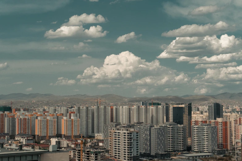 clouds move in over a city beneath the blue sky