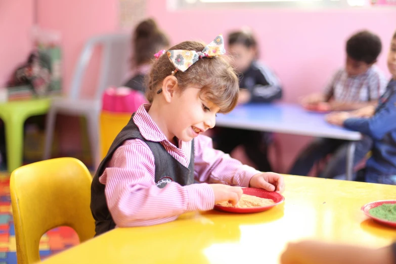 the little girl is making her name on a plate