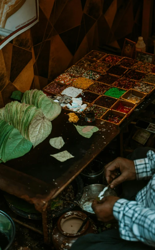 a man sitting on a chair next to a table filled with plants