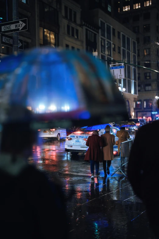 two people walk in the rain under umbrellas