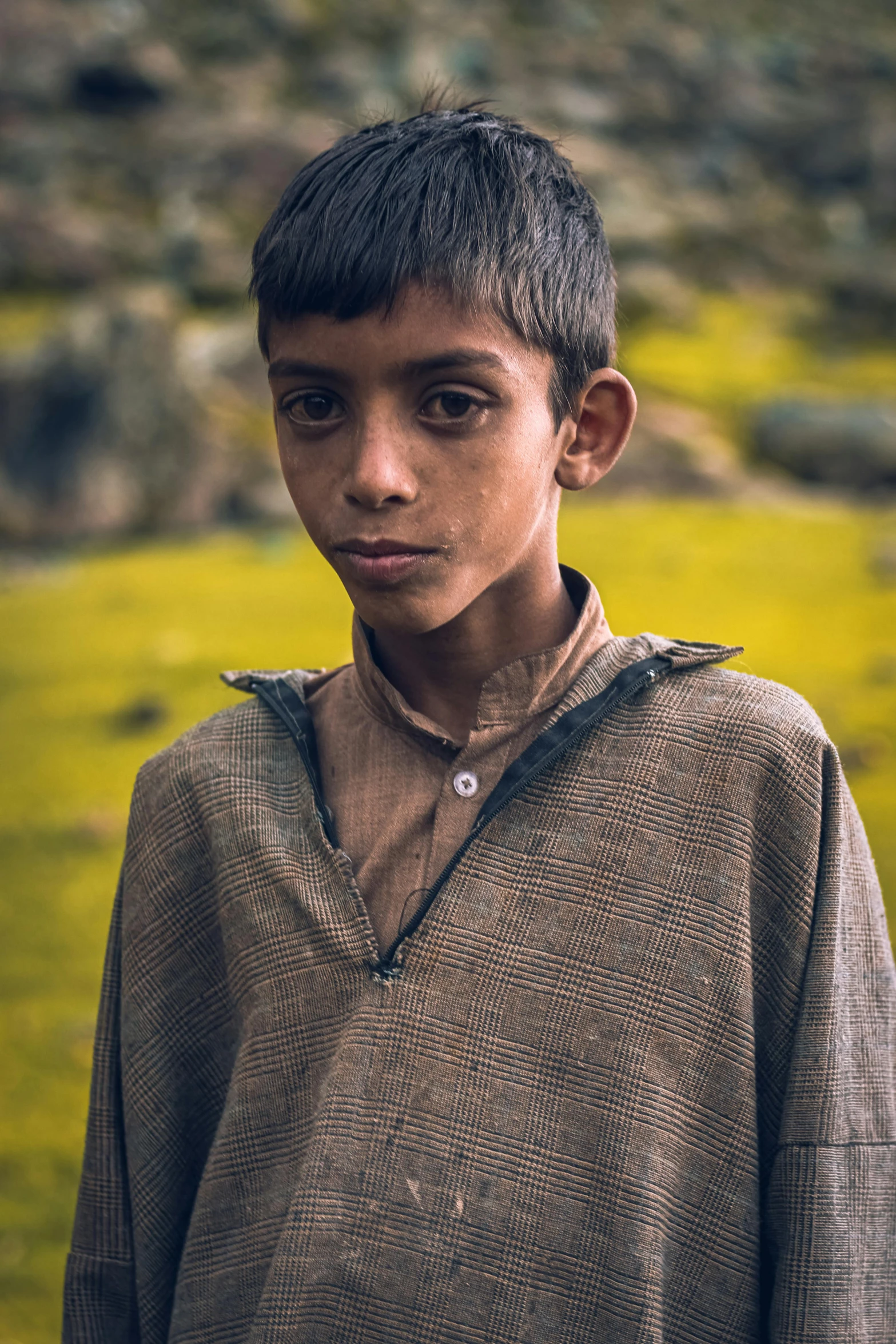 a boy in the middle of a field with green grass