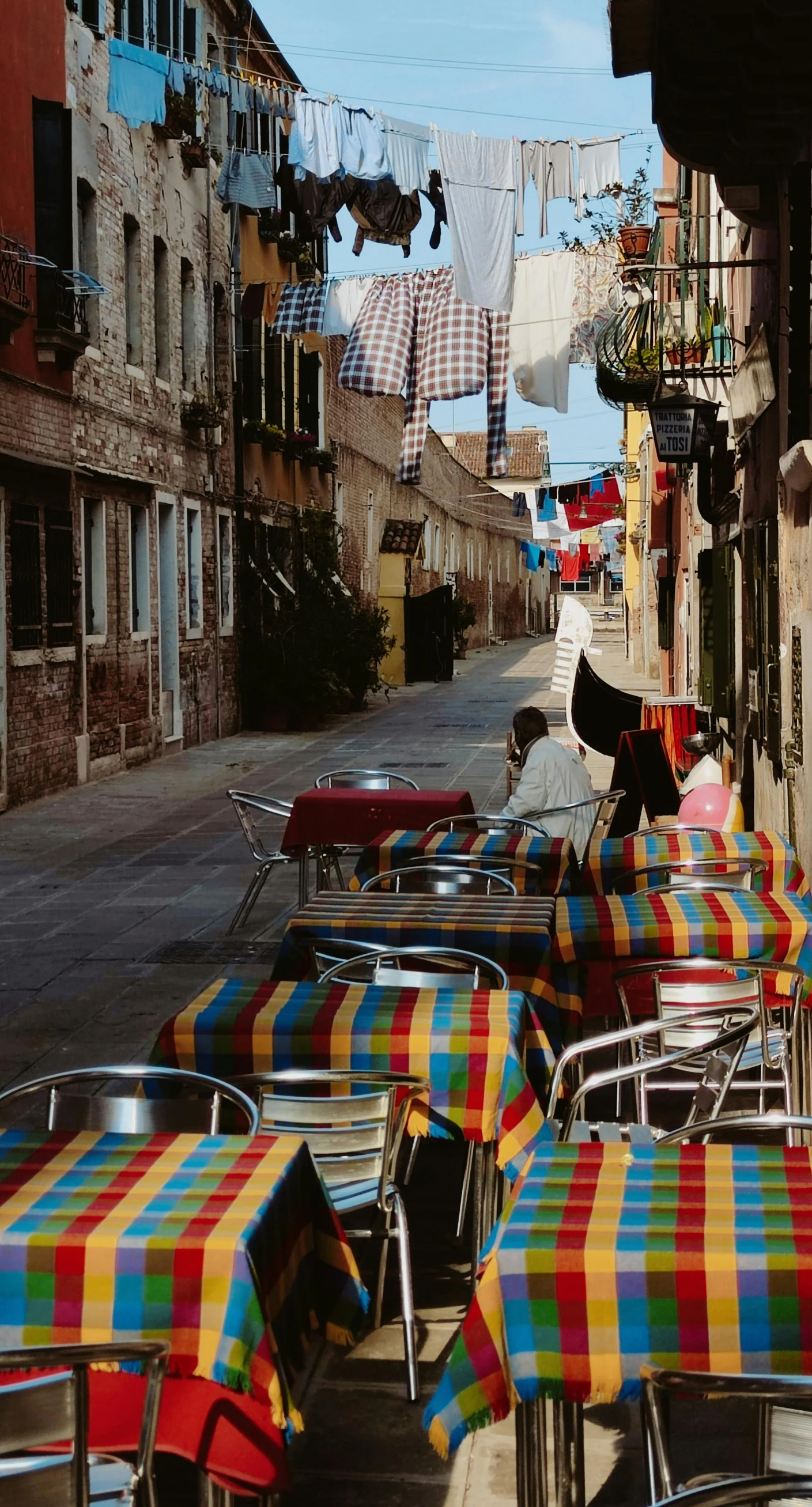 a sidewalk that has some tables and chairs on it