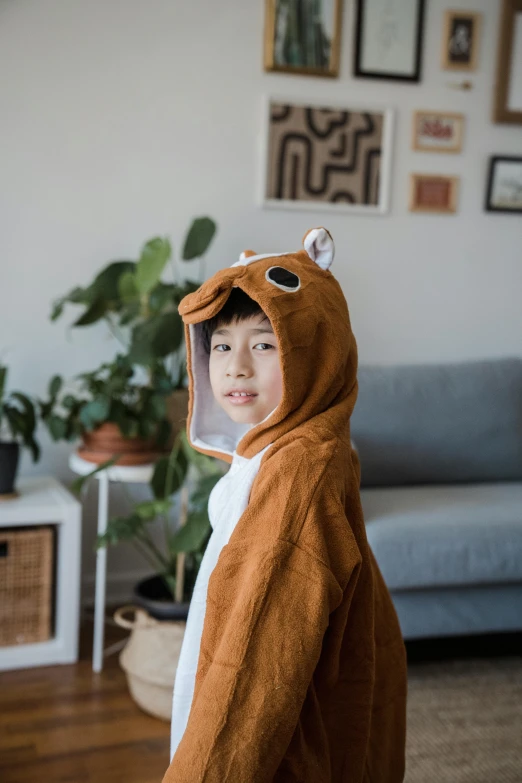a child wearing a costume in the shape of a bear