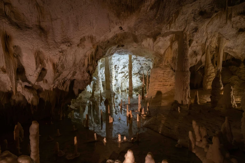 a group of people in a cave with the light from a window on them