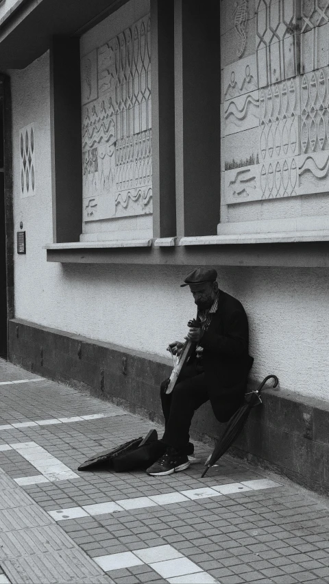 a man sitting on the curb by a building