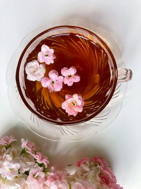 flowers are floating in a drink from a cup